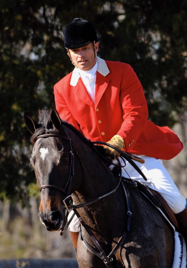 Huntsman in red coat riding dark horse - Al Griffin