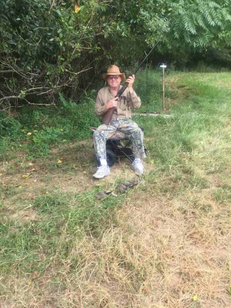 Man sitting on chair with rifle